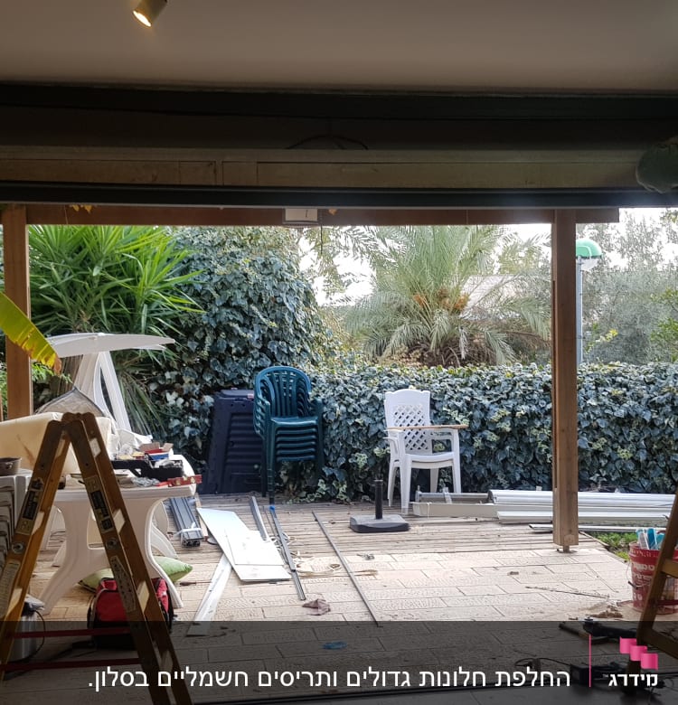 אדם עובד על מסגרת אלומיניום בדלת גדולה